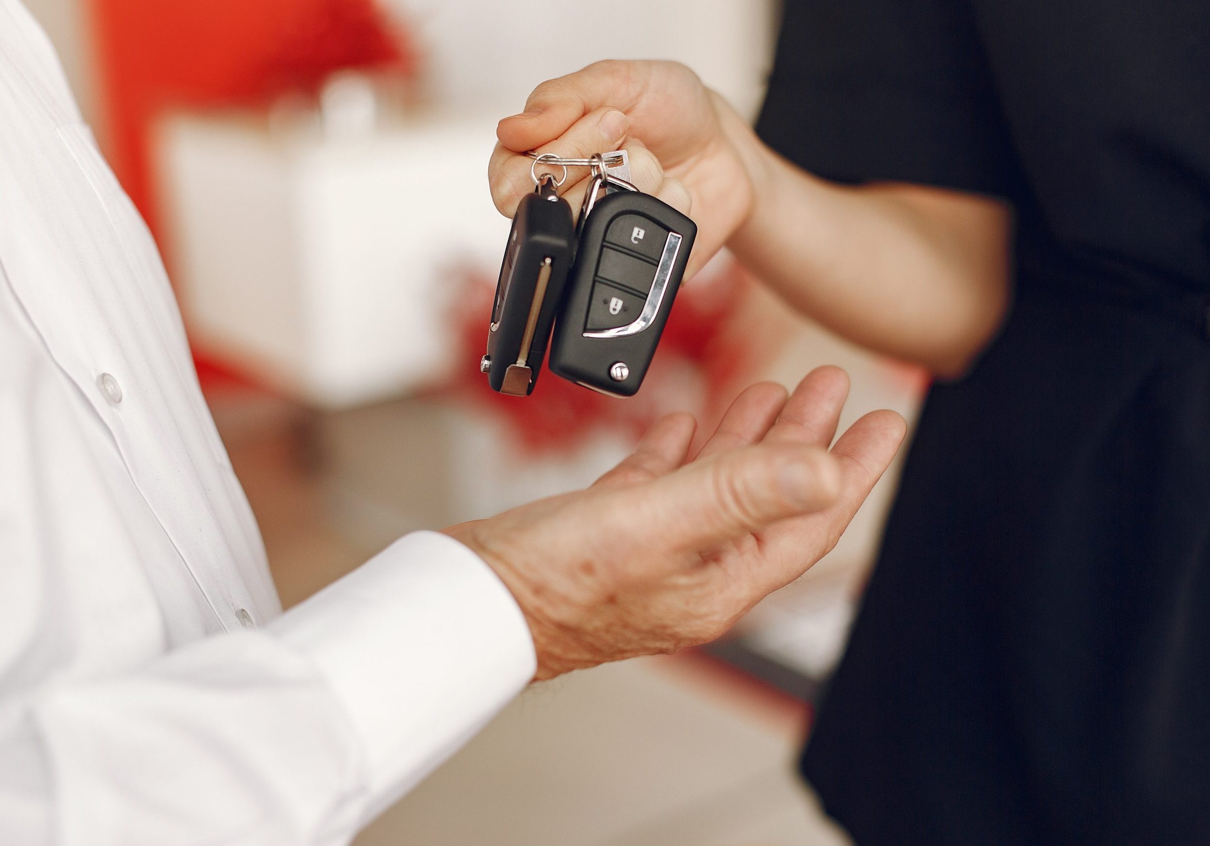 Senior in a car salon. Old man buying the car. Elegant woman helps a man buy a car.